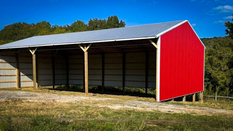 pole barn equipment shed red with blue sky and trees